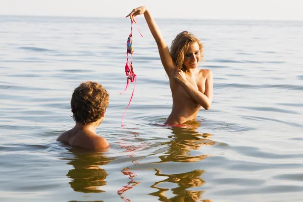 Sexy meisje uitkleden in het water met vriendje — Stockfoto
