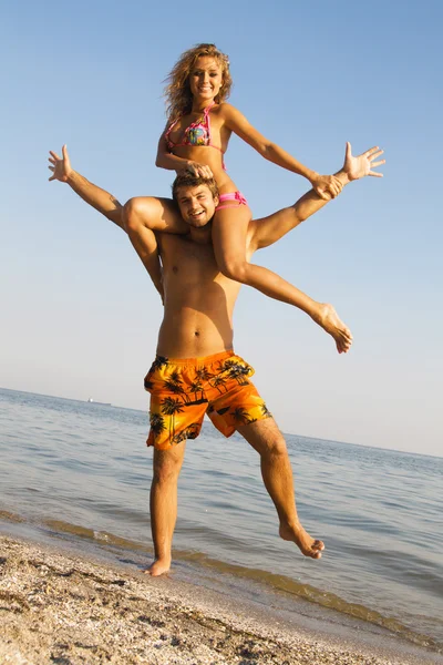 Забавная молодая пара на берегу моря — стоковое фото