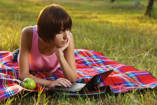 Chica encantadora con portátil en el picnic — Foto de Stock