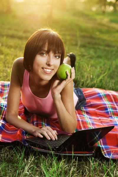 Härlig tjej med laptop på picknick — Stockfoto