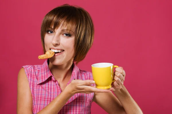 Menina bonito com um biscoito e xícara de chá — Fotografia de Stock