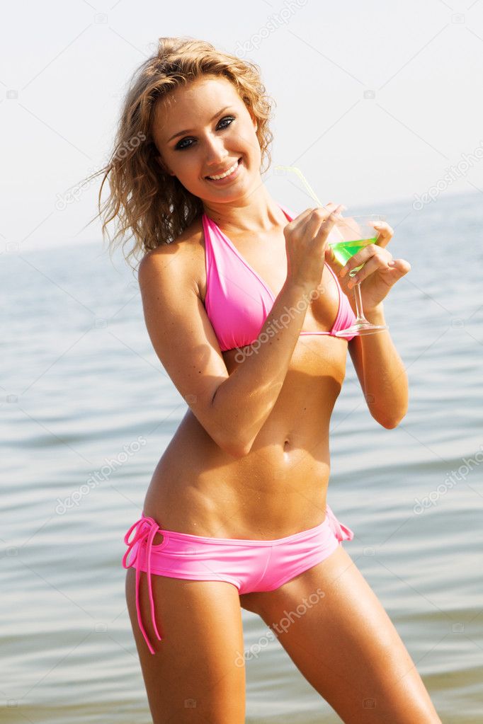 Beautiful woman with cocktail at the seaside