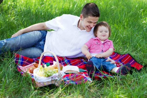 Joven familia de tres en un picnic —  Fotos de Stock