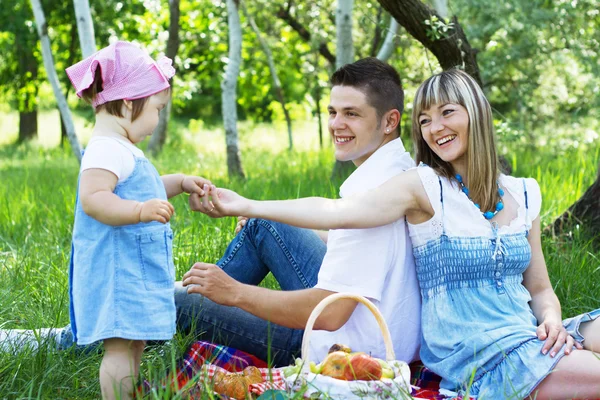 Joven familia de tres en un picnic —  Fotos de Stock
