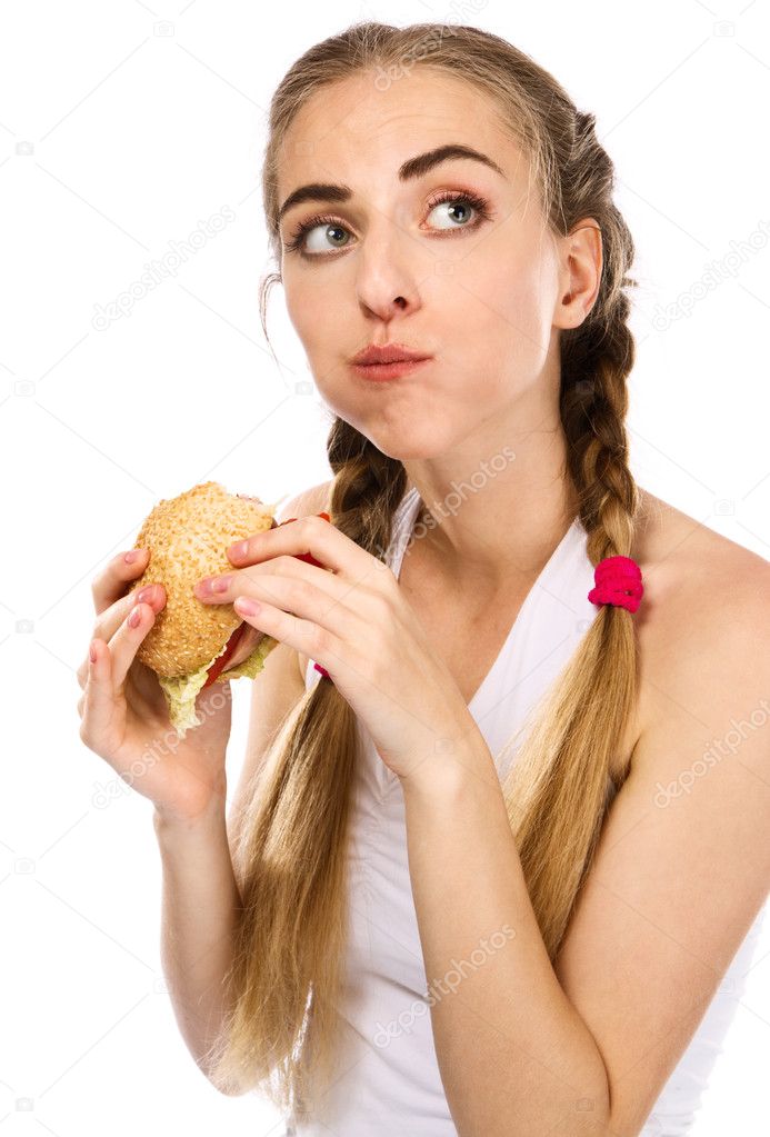 Young woman holding a hamburger and an apple