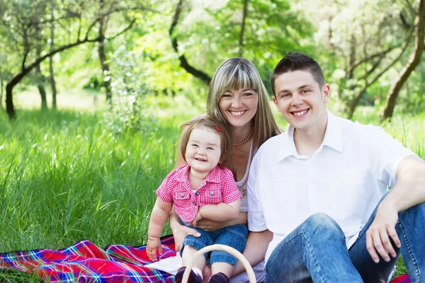 Mladá rodina ze tří na piknik — Stock fotografie