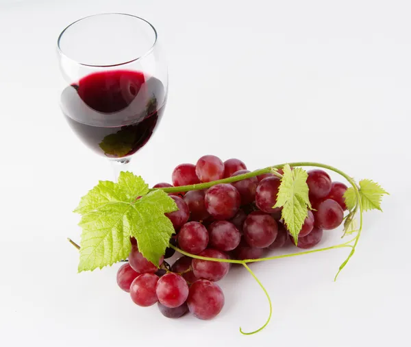 Glass of red wine with grapes — Stock Photo, Image