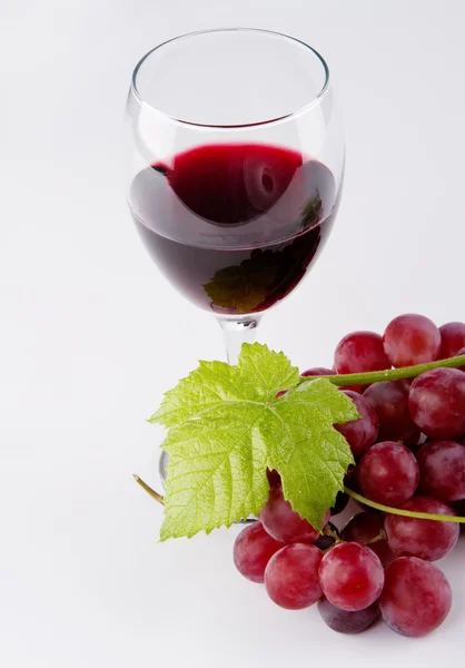 Бокал красного вина, с виноградом на переднем плане — стоковое фото