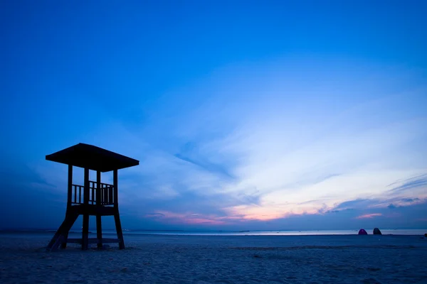 Observationstårn på stranden med solopgang - Stock-foto