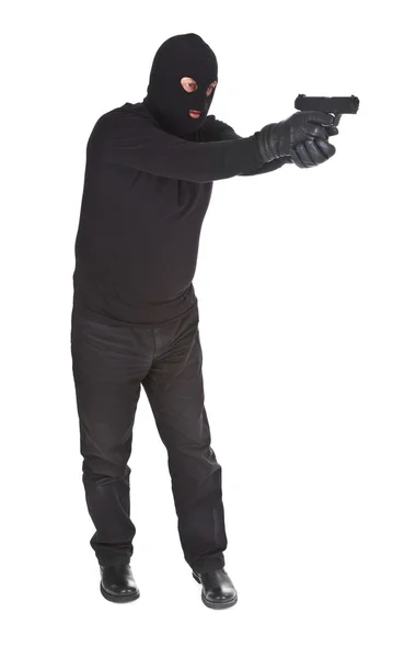 Грабитель целится из пистолета. — стоковое фото