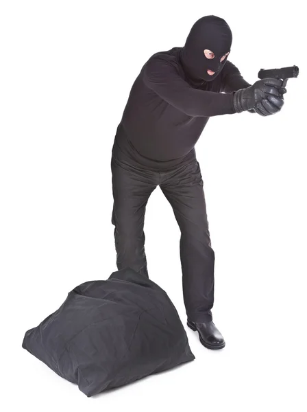 Грабитель с мешком, целится из пистолета. — стоковое фото
