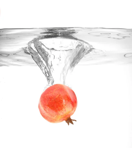 Ripe pomegranate falling into water — Stock Photo, Image