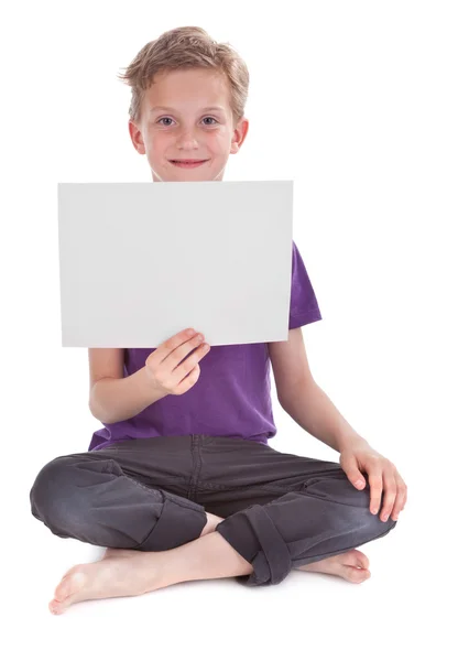 Kluk sedí a drží prázdné bílé stránky — Stock fotografie