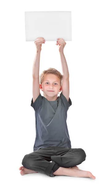 Boy sitting and holding a blank white page — Stock Photo, Image
