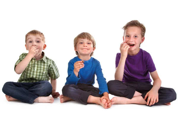 Drei Kinder essen Süßigkeiten — Stockfoto