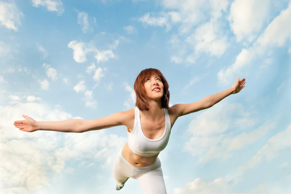Donna atletica in equilibrio davanti al cielo blu — Foto Stock