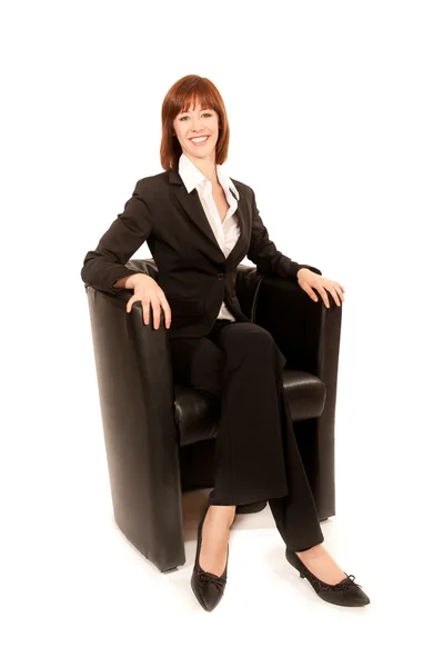 Young business woman sitting in black armchairs — Stock Photo, Image