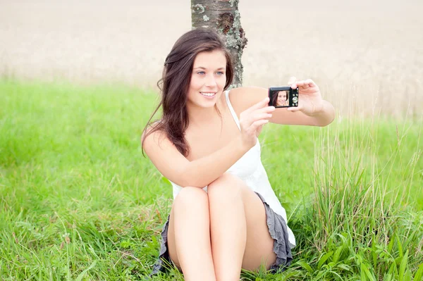 Adolescente bonito tomando auto-retrato com câmera digital — Fotografia de Stock