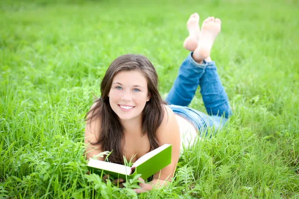Retrato ao ar livre de um adolescente leitura bonito — Fotografia de Stock