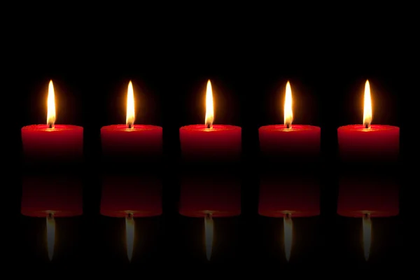 Cinco velas rojas ardientes frente al fondo negro — Foto de Stock