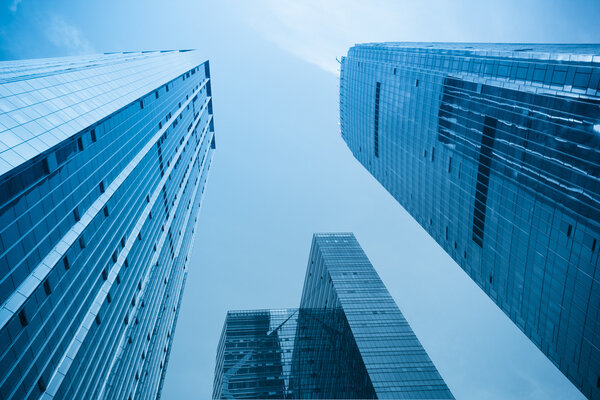 Modern office background of glass building with blue tone
