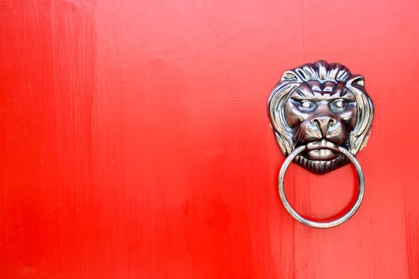 Batedor de leão na porta vermelha — Fotografia de Stock