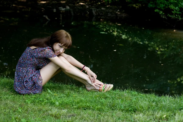 Hermosa chica sentada en la orilla de un río —  Fotos de Stock