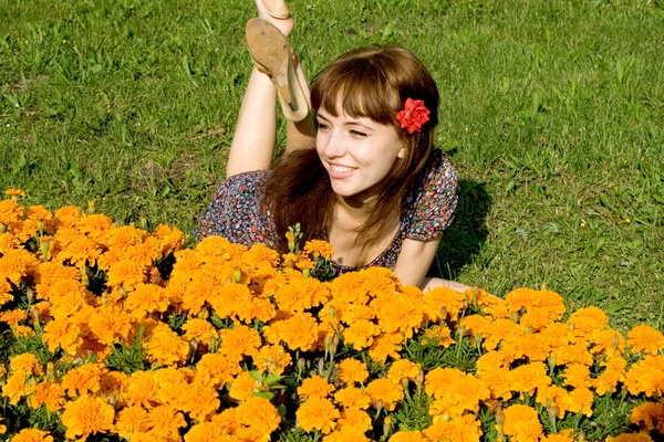 Krásná dívka leží na louce s květy — Stock fotografie