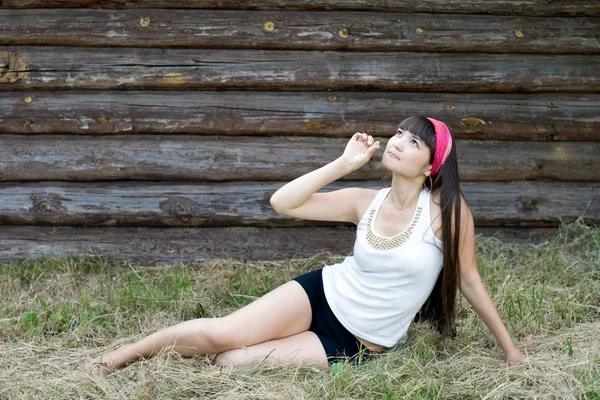 Mooi meisje, zittend op hooi — Stockfoto