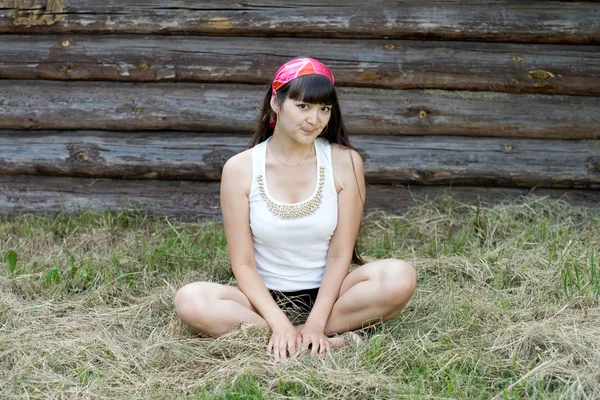 Красивая девушка сидит на сене — стоковое фото