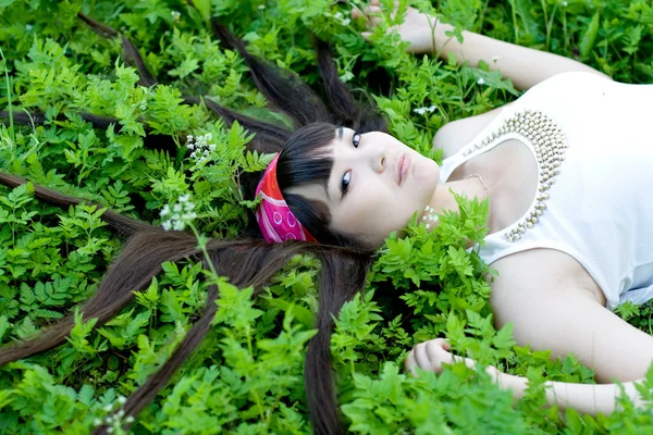 花の中で横になっている美しい女の子のクローズ アップの肖像画 — ストック写真