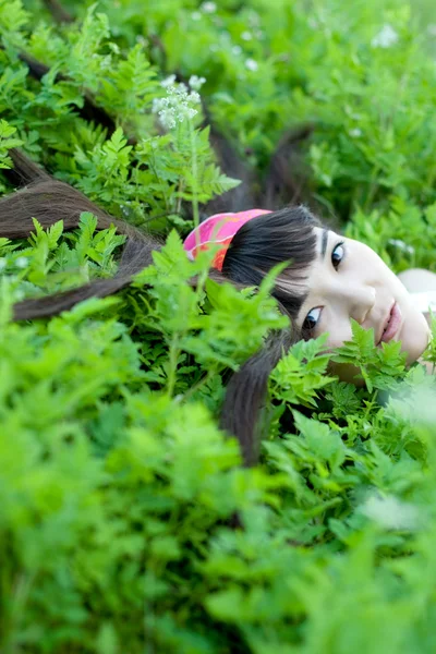 Nahaufnahme Porträt eines schönen Mädchens, das zwischen Blumen liegt — Stockfoto