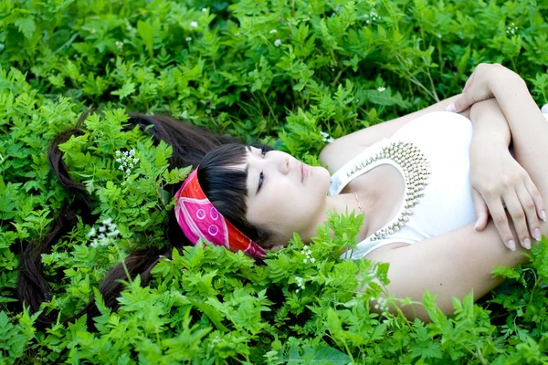 Closeup portrait of a beautiful girl lying among flowers — Stock Photo, Image