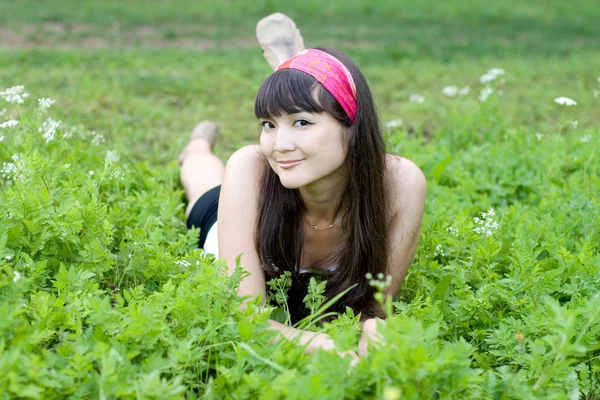 Chica bonita acostada en la hierba — Foto de Stock