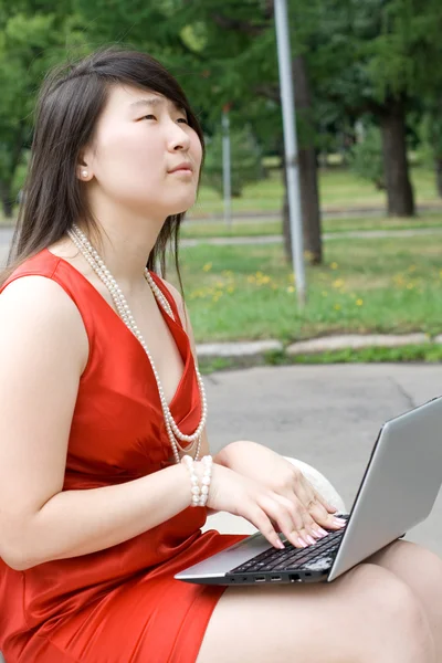 Meisje bezig met laptop buiten — Stockfoto