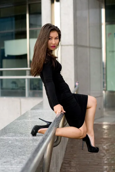 Sexy girl in black dress walking in city — Stock Photo, Image