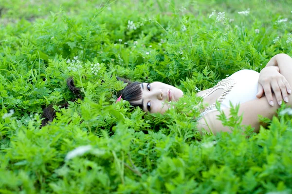 Retrato de close-up de uma linda menina deitada entre as flores — Fotografia de Stock