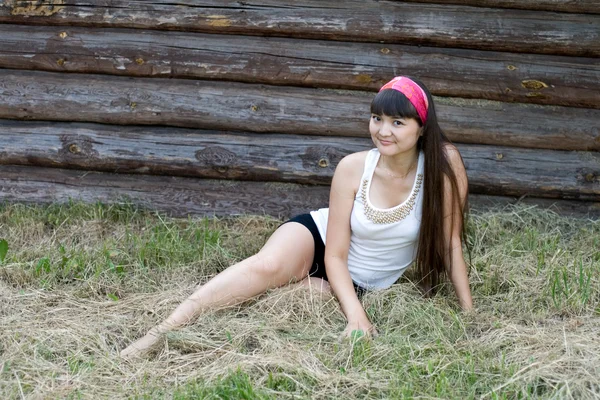 Красивая девушка сидит на сене — стоковое фото