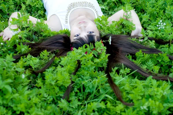 Närbild porträtt av en vacker flicka liggande bland blommor — Stockfoto