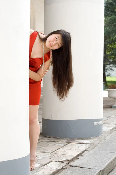 Hübsches Mädchen versteckt sich zwischen Säulen — Stockfoto
