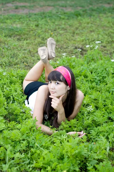 Söt flicka liggande på gräs — Stockfoto