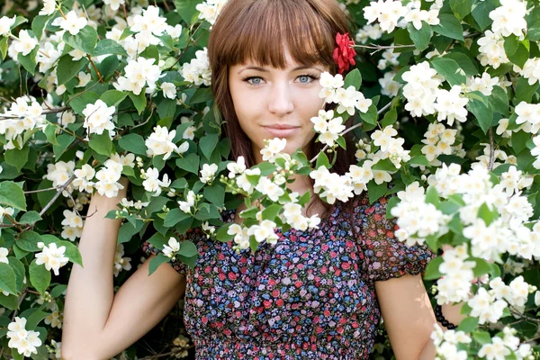 Primo piano ritratto di una bella ragazza in piedi tra i fiori — Foto Stock