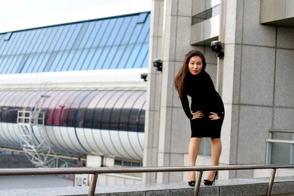 Sexig tjej i svart klänning promenader i city — Stockfoto