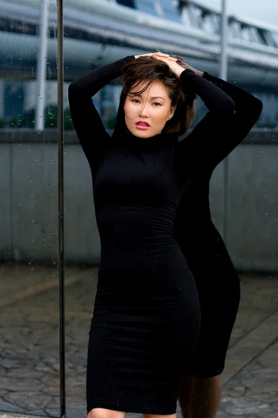 Szexi lány fekete ruhában állt a tükör előtt — Stock Fotó