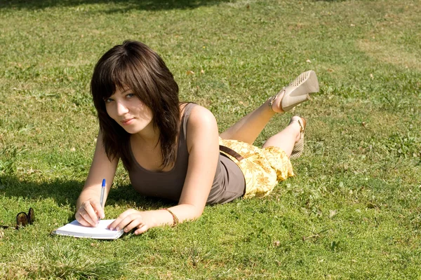 Девушка лежит на траве в парке — стоковое фото