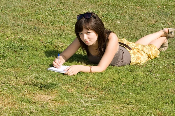 Девушка лежит на траве в парке — стоковое фото
