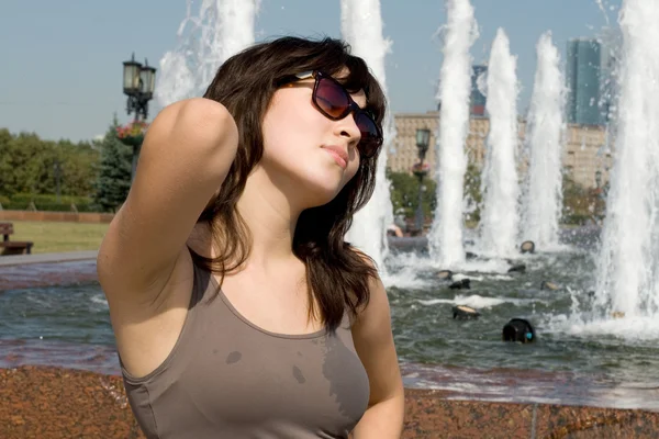 Девушка ходит рядом с фонтаном в городе — стоковое фото