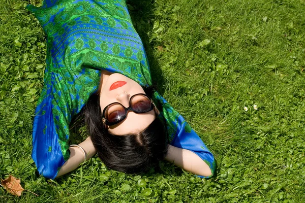 Dziewczyna leżące na trawie w parku — Zdjęcie stockowe