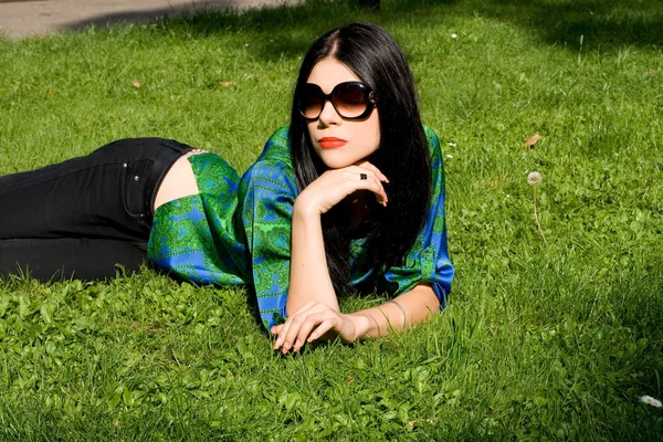 Chica acostada en la hierba en el parque — Foto de Stock