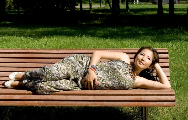 美しい妊娠中の女の子のベンチに横になっています。 — ストック写真